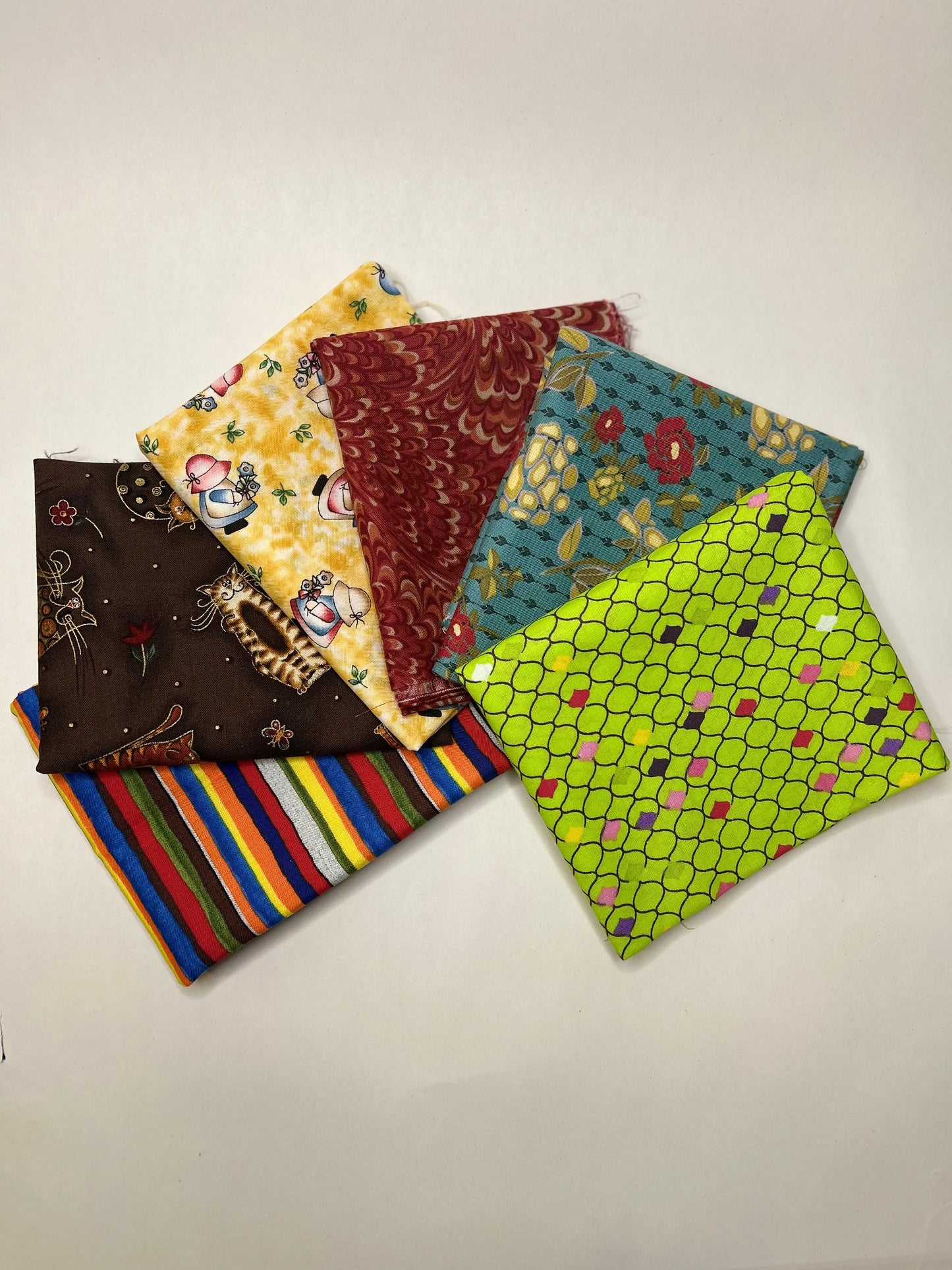 Collection of colorful fabric fat quarter swatches on a white background