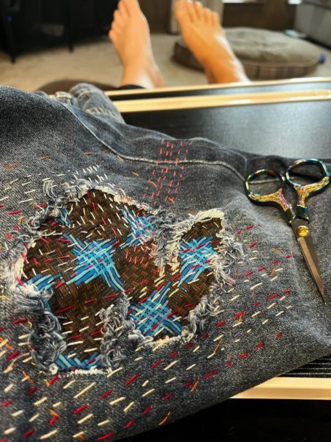 jeans with visible stitching around it in red and white