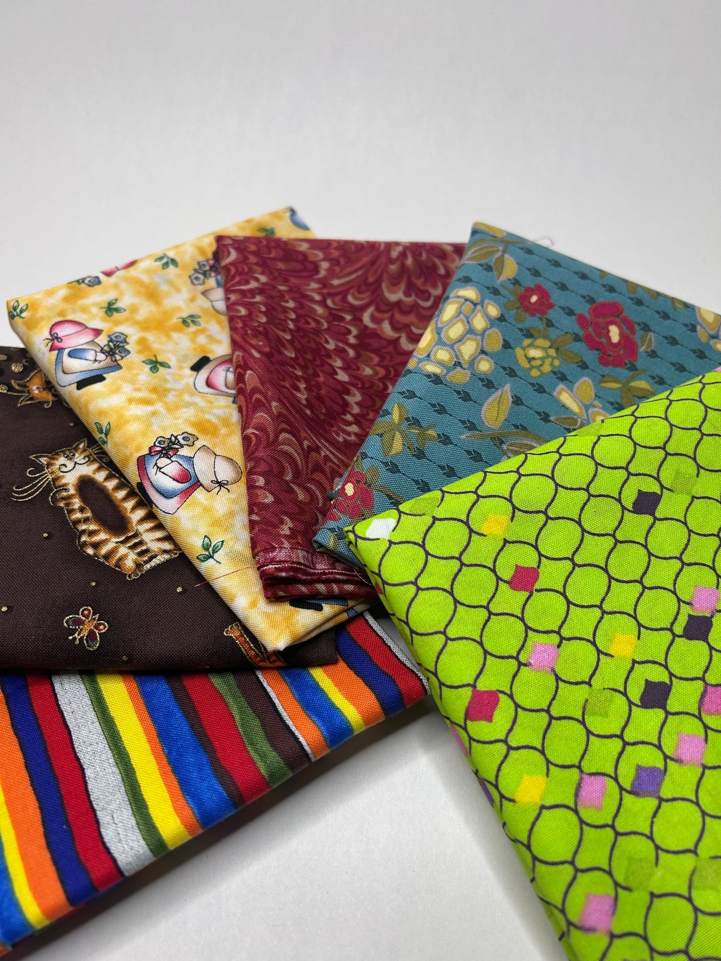 Collection of colorful fabric fat quarter swatches on a white background