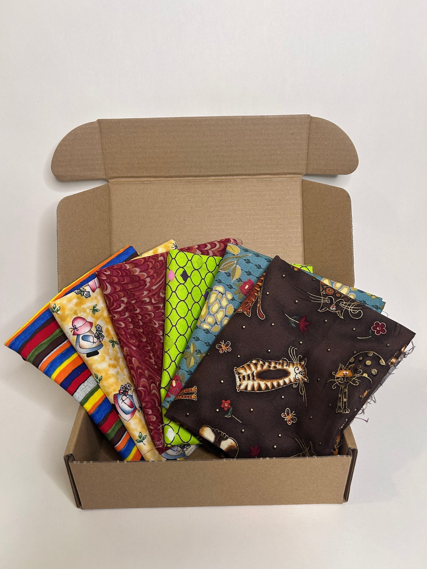 Open cardboard box subscription with colorful fabric swatches inside 
