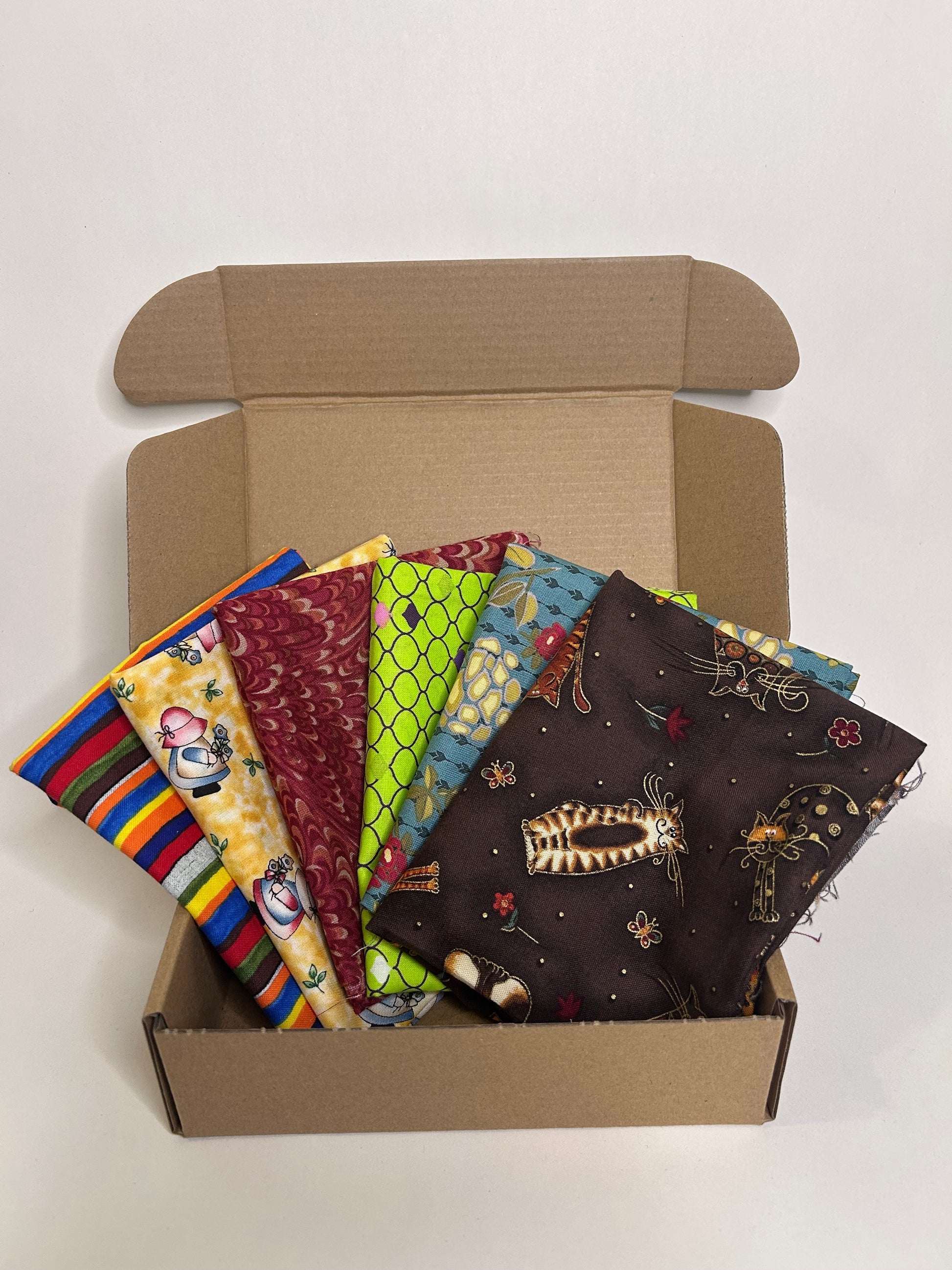 Open cardboard box subscription with colorful fabric swatches inside 